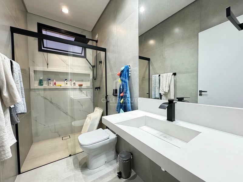 Casa para Locação | Condomínio Verana Parque Alvorada – Marília/SP  Viva com conforto, tecnologia e sofisticação em um dos condomínios mais desejados de Marília.  Esta excelente residência foi projetada para oferecer praticidade, segurança e qualidade de vida para toda a família.  Destaques do imóvel  * 4 dormitórios, sendo 1 suíte; * 3 banheiros + 1 lavabo; * Ampla sala com pé-direito alto; * Área gourmet integrada; * Piscina; * 2 churrasqueiras; * Cozinha planejada com armários; * Armários no quarto de solteiro; * Água quente em todas as torneiras e chuveiros (boiler); * Preparação para ar-condicionado em todos os ambientes; * Preparação para carregador de veículo elétrico; * Janelas dos dormitórios e porta-balcão automatizadas, com comando por Alexa; * Iluminação em LED em toda a residência; * Construção totalmente em laje; * 206 m² de área construída; * Aproximadamente 70 m² de área de depósito.  Uma casa moderna, funcional e preparada para quem valoriza conforto, tecnologia e ambientes amplos, ideal para famílias que desejam morar com tranquilidade e segurança dentro do Condomínio Verana Parque Alvorada.  Agende sua visita e conheça pessoalmente este imóvel exclusivo.  Caléb Souto | Negócios Imobiliários Especialista em casas de condomínio em Marília.: 20ª foto da galeria de imagens do imóvel